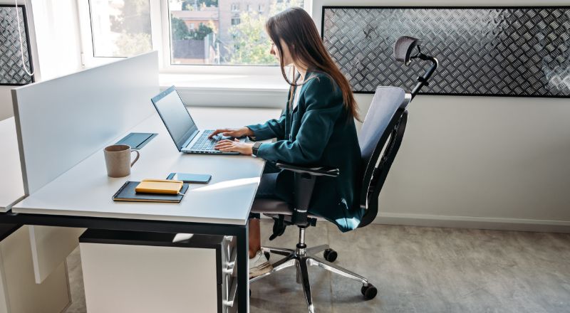 mulher em escritório digitando em notebook