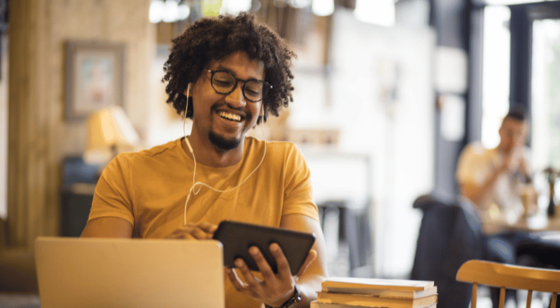 Homem sorridente olhando um celular.