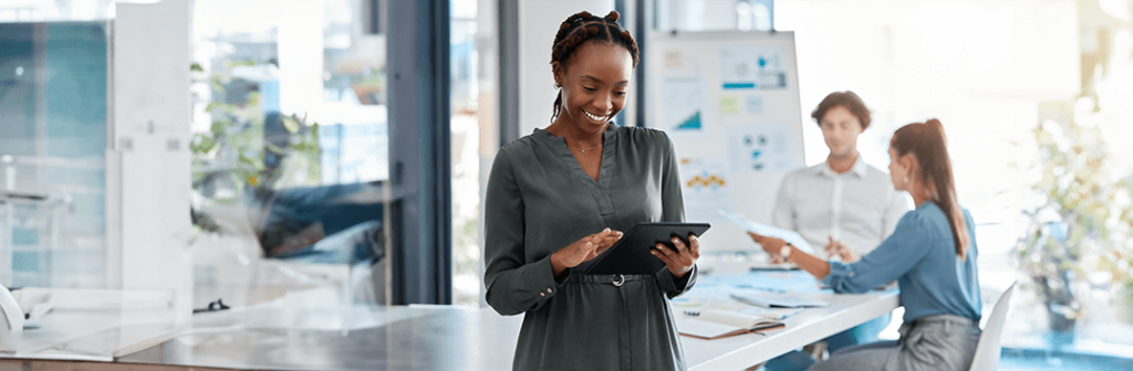 Mulher negra sorridente conferindo a pesquisa Safe of Search 2023 em um tablet preto.