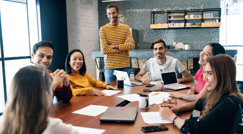 Grupo de pessoas reunidas no trabalho discutindo o que é SEO.