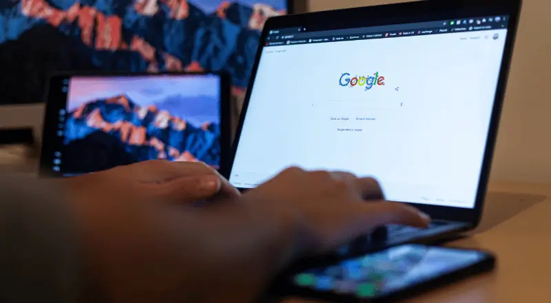 Imagem mostra pessoa moxendo no notebook e na tela está a página de busca do Google.