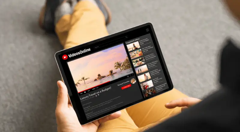 Homem assistindo um vídeo em uma plataforma que representa o Youtube, em um tablet.