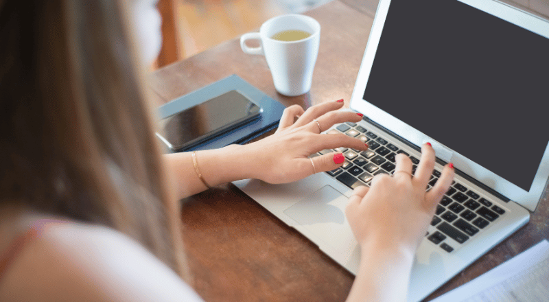 Google Tag Manager: Saiba a importância para seu site e e-commerce Imagem mostra mulher teclando em um notebook branco.