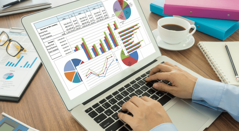 KPIs: A importância de medir e analisar os resultados do SEO pessoa teclando em um notebbok cheio de gráficos.