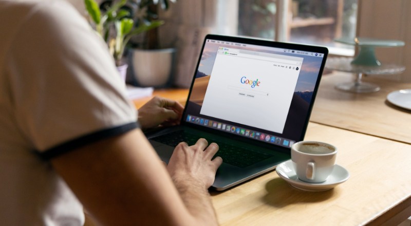 Novo Update Google para SEOs: Teremos mais transparência sobre os fatores de classificação de busca? Mãos acessam um computador buscando as Novidades do Google