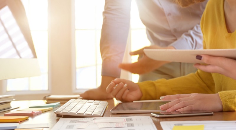Tem um site WordPress? Conheça o novo plugin que facilita a performance da sua página na web! Duas pessoas conversando em uma mesa de trabalho