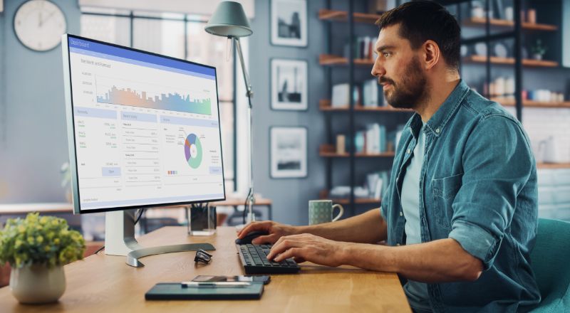 Novidade no Shopify: Eleve o SEO da sua loja com o plugin Yoast Homem mexendo no computador e analisando resultados