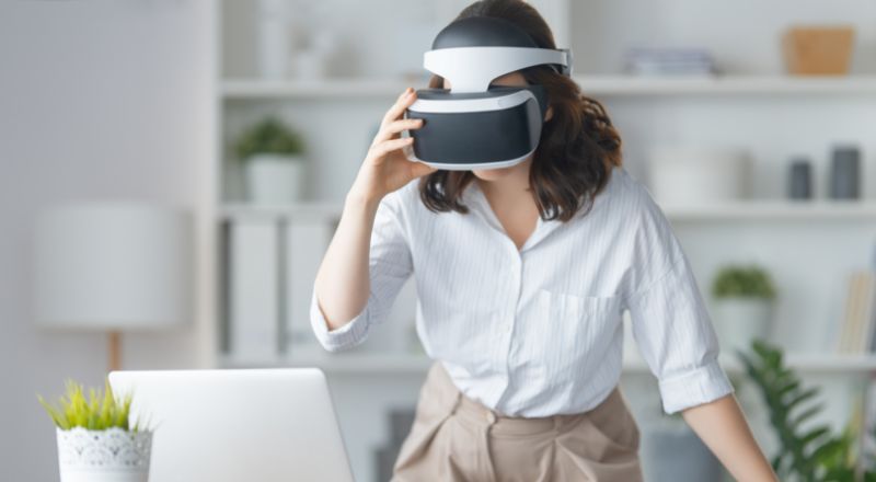 Metaverso: o que é e como entrar neste mercado? mulher utilizando oculos de realidade virtual para acessar o metaverso