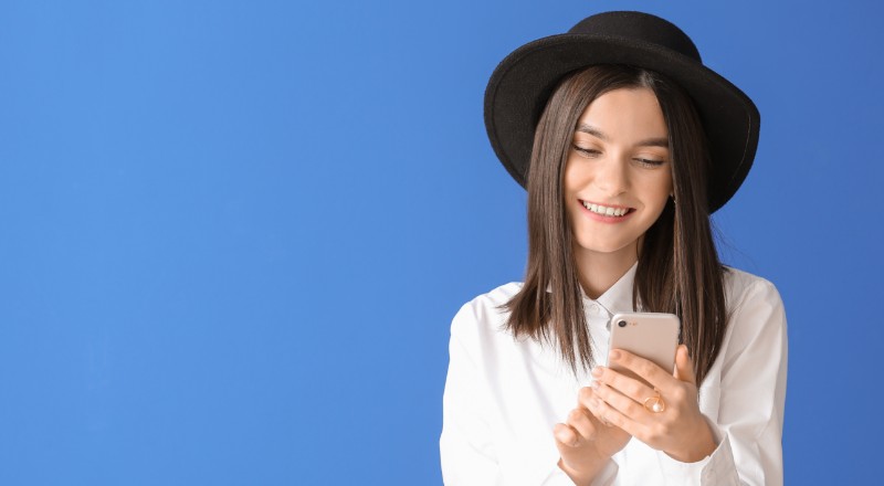 Google Web Stories: Conheça esta nova ferramenta do Google Menina sorridente mexendo no celular