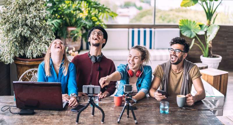 Algoritmo do Instagram: Você sabe realmente como funciona o Reels? Grupo de amigos sorri e mexe com aparelhos tecnológicos
